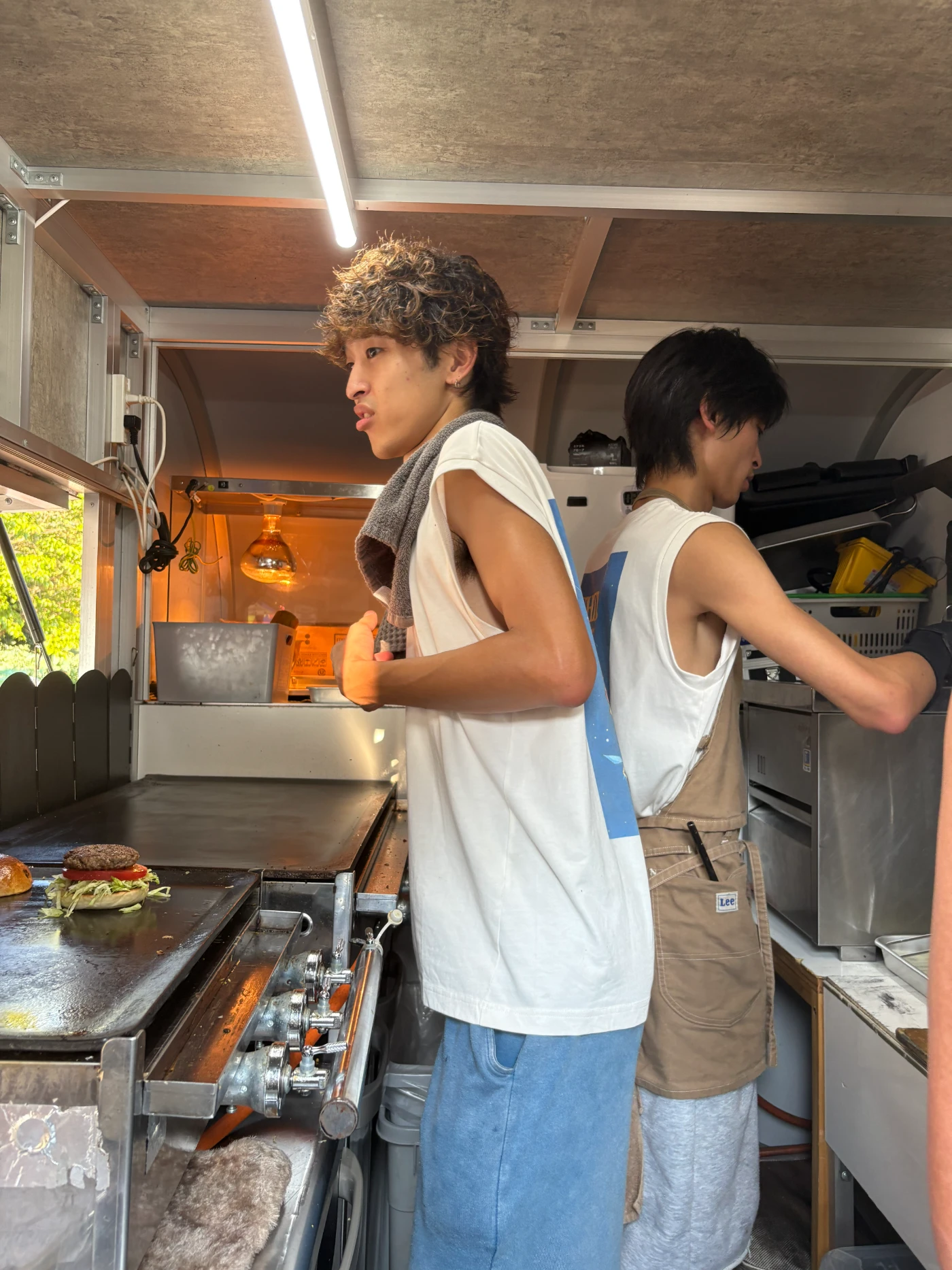 キッチンカーの中で背中合わせに調理する、ひなたとかえで